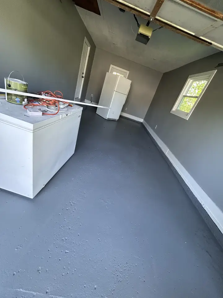 Finished garage conversion with gray walls and coated floor